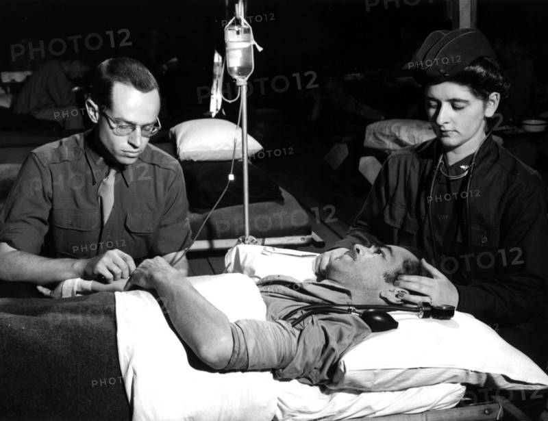A US former POW receives unit of blood plasma at a Normandy hospital (May 5, 1945)