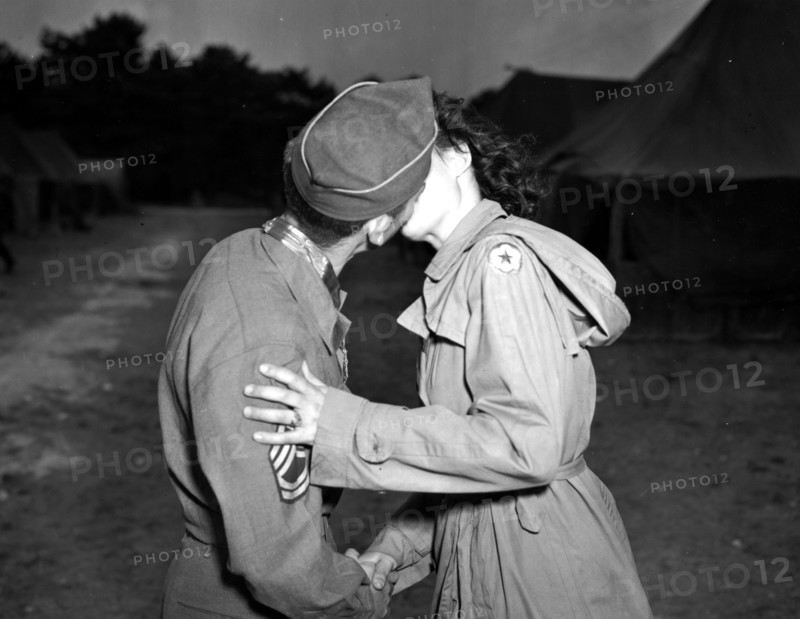 Sergent de l'U.S. Army embrassant une jeune femme du corps d'armée féminin U.S.
(25 Juillet 1945)