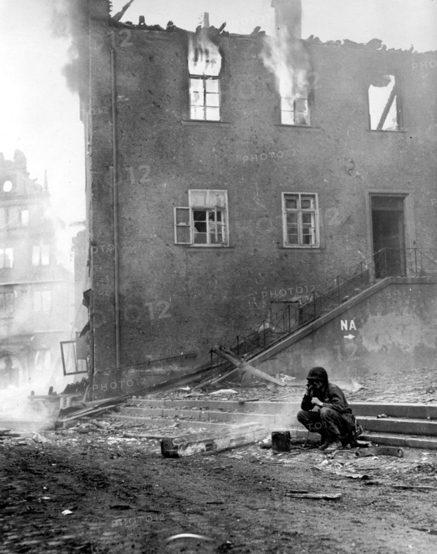 U.S soldier checks wiring as Gemunden (Germany) burns, April 6,1945
