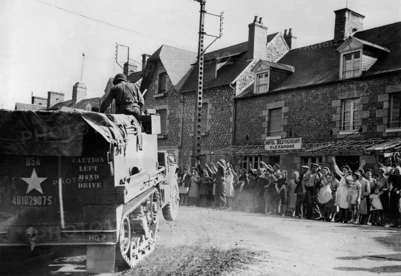 Les habitants de Sartilly saluent les troupes américaines en Normandie. 
(Eté 1944)