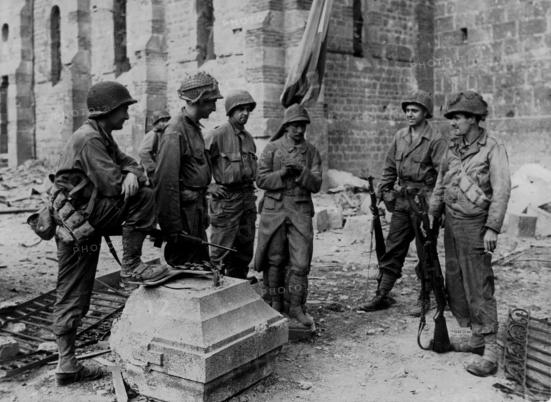 Soldats américains autour de la base d'un monument commémorant les soldats de la Première guerre mondiale (été 1944).