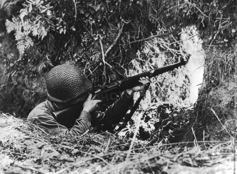 An American infantryman shoots at enemy on the Vire front, summer 1944
