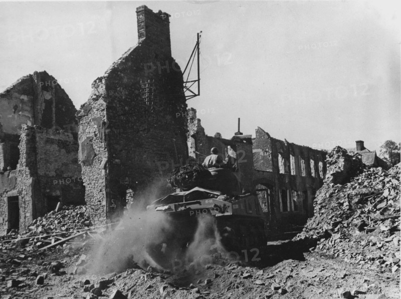 A M-4 Sherman tank crossing the town of Périers, heading towards Coutances