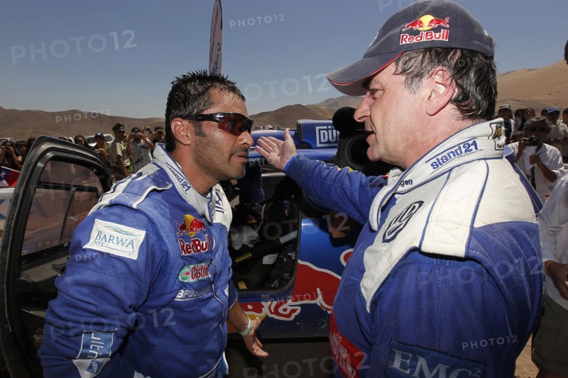 VW Race Touareg-Pilot Nasser Al-Attiyah (l) aus Katar und sein Teamkollege Carlos Sainz aus Spanien unterhalten sich am Montag (10.01.2011) nach der 8. Etappe der Rallye Dakar von Antofagasta nach Copiapo, Chile. Foto: Volkswagen/DPPI (ACHTUNG: Handout - Nur zur redaktionellen Verwendung und bei Nennung der Quelle: Volkswagen/DPPI )