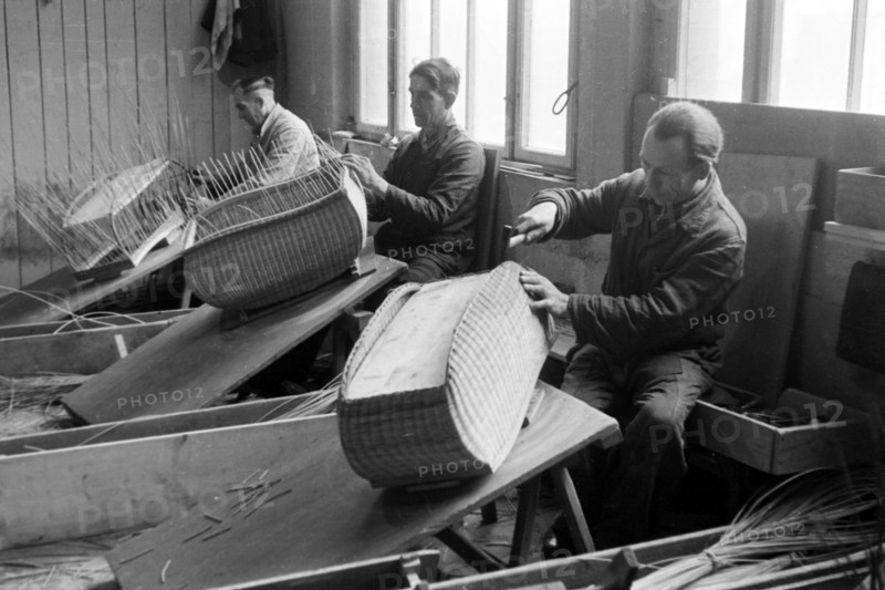 Arbeiter der Kinderwagenfabrik Zekiwa beim Flechten des Kinderkorbs für Kinderwagen in der Fabrik in Zeitz, Deutschland 1948. Workers binding the baby baskets for prams at the factory in Zeitz, Germany 1948. | Verwendung weltweit