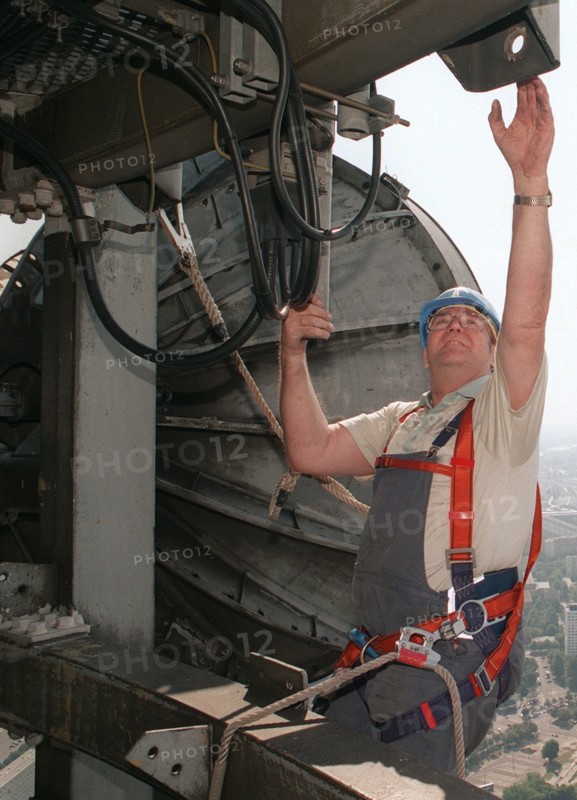 ServicetechnikerWolfgang Jahnke ist vorschriftsmässig mit einem Geschirr gesichert, als er damit beschäftigt ist, in 330 Meter Höhe auf dem Berliner Fernsehturm einen Richtfunkstrahler zu demontieren