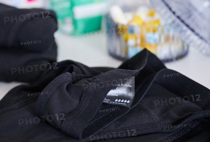 The label of period underwear symbolically depicts five drops for strong absorbency. (posed scene) Behind the underwear is a container of tampons and a pack of pads. Period underwear is increasingly conquering the market and, according to manufacturers, is intended to be an environmentally friendly alternative to disposable products. (To dpa: "Sustainable period panties? Experts warn against biocides")