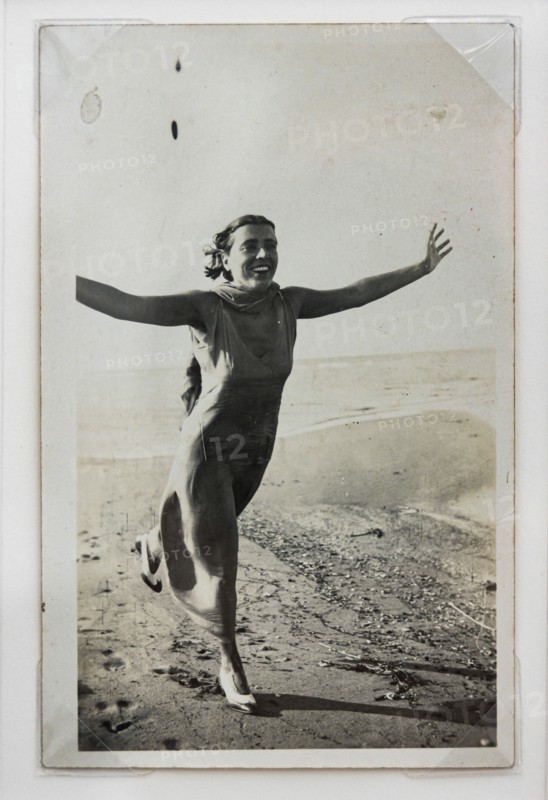 “Donna che corre sulla spiaggia con braccia aperte"