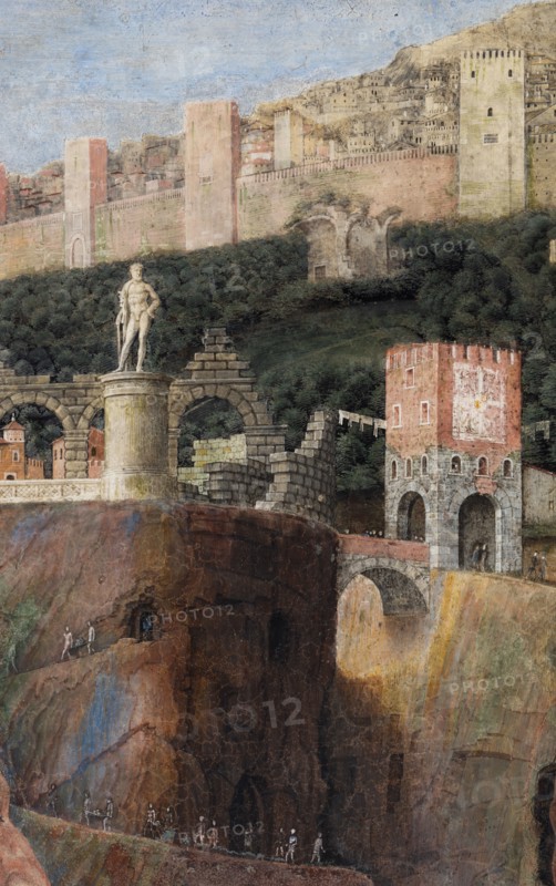 Ducal Palace: south-west wall of the “Bridal Chamber or Camera Picta", which is a room located in the north-east tower of the Castle of San Giorgio in Mantua. It is famous for the cycle of frescoes that covers its walls, a masterpiece by Andrea Mantegna, created between 1465 and 1474.
The wall, on the theme of “The Meeting” is divided into three sectors. In the one on the left the actual meeting takes place, in the central one some cherubs hold a dedicatory plaque and in the one on the right the marquis's court parades.
Detail of the right part of the wall.
 In the background an ideal view of Rome is represented, in which there ancient monuments such as the Colosseum, Castel Sant'Angelo, the pyramid of Cestius, the theater of Marcellus, the Nomentano bridge, the Aurelian Walls, etc. cani be recognised. Mantegna also invented some monuments  such as a colossal statue of Hercules.
Palazzo Ducale, Mantova (MN) - Mantua, Lombardia - Lombardy, Italia - Italy