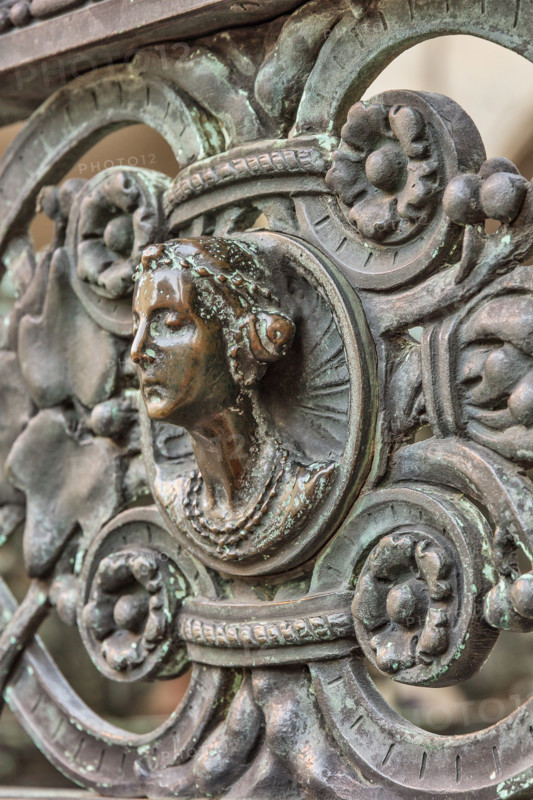 Bergamo, Città alta, Cappella Colleoni, Cancellata in ferro battuto realizzata nel 1912 da Vincenzo Muzio, su disegno di Gaetano Moretti: particolare con testa di donna.

[ENG]
Bergamo, Città alta, Cappella Colleoni (Colleoni Chapel), iron wrought gate realised by Vincenzo Muzio in 1912, according to a drawing by Gaetano Moretti: detail with a woman's head.
Bergamo (BG), Lombardia - Lombardy, Italia - Italy