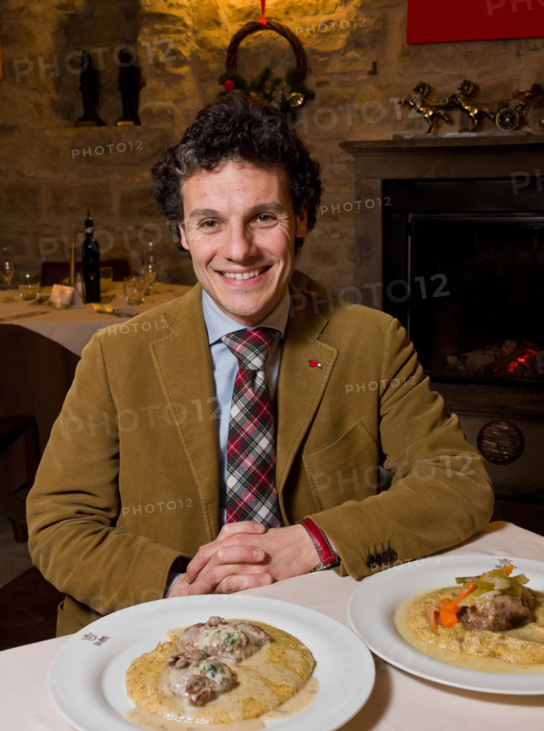 Città alta, Ristorante DAMIMMO:  Massimo Amaddeo, uno dei titolari, siede a un tavolo davanti a due piatti della cucina bergamasca (guancialino stufato con lesso di verdure e polenta, e oseli scapacc alle erbette e Branzi d'alpeggio).
Bergamo (BG), Lombardia, Italia - Italy