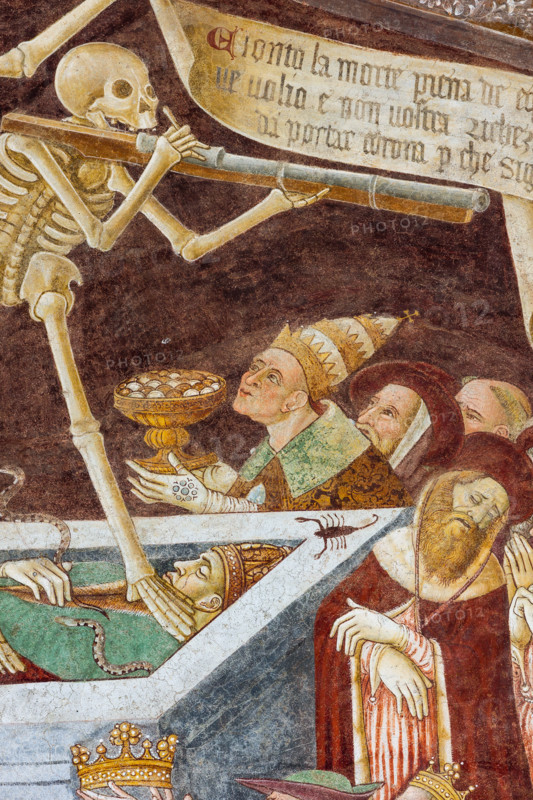 Clusone, Oratorio dei Disciplini o di San Bernardino, facciata: affreschi  "Trionfo della Morte" (parte alta) e "Danza Macabra" (parte bassa), 1485. Opera dell'artista clusonese Giacomo Borlone De Buschis.
Dettaglio del Trionfo della Morte: La Morte si trova sopra un sarcofago al cui interno si trovano ormai privi di vita il Papa e l’Imperatore con intorno serpenti, rospi e scorpioni (simboli di superbia e morte improvvisa). La Morte tiene in mando grossi cartigli che ricordano che  tutti sono destinati a lasciare il mondo terreno.

[ENG] 
Clusone, Oratory of Disciplini or St. Bernardino, façade: frescoes with the Triumph of Death on the top and a Dance of Death (Macabre Dance) in the lower register (1485). All the frescoes are by Giacomo Borlone De Buschis.
Detail of the Triumph of Death standing on a sarcophagus where the dead Pope and the Emperor lie. Theay are surrounded by serpents, scorpions and toads (symbols of pride and sudden death). Death hold big scrolls to remind ever...