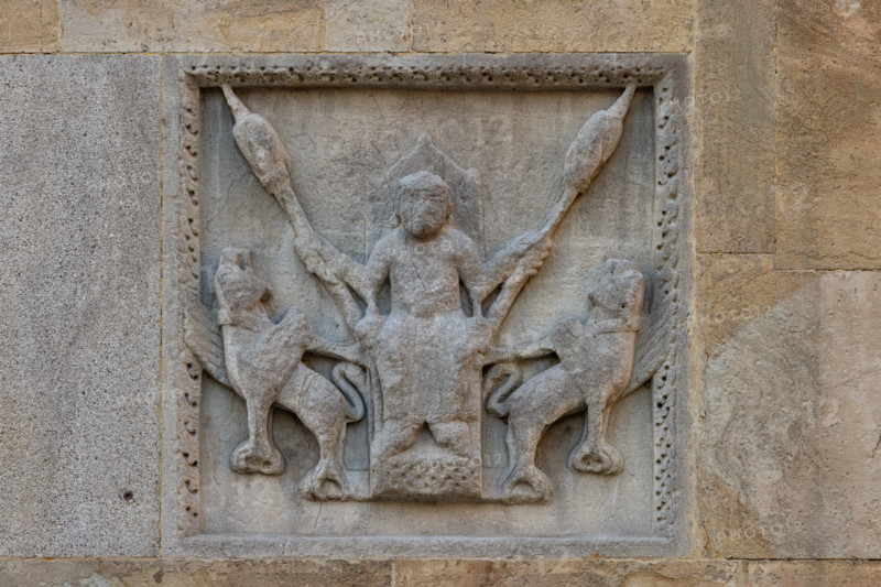 Fidenza, duomo (cattedrale di San Donnino), torre di destra (Torre del Trabucco), fronte ovest:  “Il Volo di Alessandro Magno”. 
Una leggenda ripresa dal Romanzo di Alessandro dello Pseudo-Callistene narra che Alessandro, per potersi levare in volo, attaccò al proprio cocchio due grifoni; poi infilzò su due lance grossi pezzi di carne in modo tale che, tenendole in alto, i grifoni fossero costretti, nella brama di afferrare la carne, a librarsi in volo trascinando così il cocchio verso l'alto. 
Il soggetto era tradizionalmente ritenuto “Berta che filava”.
Opera di Benedetto Antelami e bottega.


[ENG]
Fidenza, duomo (Cathedral of San Donnino), right tower (Trabucco Tower), west front:“The Flight of Alexander the Great”.
A legend taken from the Romance of Alexander by Pseudo-Callisthenes tells that Alexander, in order to take flight, attached two griffins to his chariot; then he impaled two large pieces of meat on two spears in such a way that, by holding them up, the griffins, ...