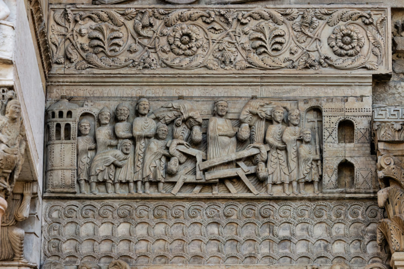 Fidenza, Duomo (Cattedrale di S. Donnino), Facciata: bassorilievo con Storie di San Donnino, "Il miracolo della donna gravida", che racconta con drammaticità l'episodio del crollo di un ponte eccessivamente affollato e il salvataggio della donna incinta per intervento del Santo. 
Benedetto Antelami e bottega.

[ENG]
Fidenza, Duomo (St. Donnino Cathedral), Façade: the bas-relief with Stories of San Donnino, "The Miracle of the Pregnant Woman", which dramatically tells the story of the collapse of an overly crowded bridge and the rescue of the pregnant woman through the intervention of the Saint. Work by Benedetto Antelami and his workshop.
Cattedrale di S. Donnino, Fidenza (PR), Emilia Romagna, Italia - Italy