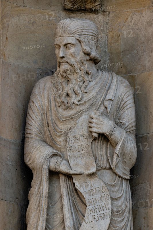 Fidenza, duomo (Cattedrale di San Donnino):
“Il Profeta Ezechiele” di Benedetto Antelami.
Il profeta sorregge un cartiglio che rimanda al significato della chiesa come "Porta del Cielo"; vi si legge: Ezechiel Propheta; vidi portam in domo Domini clausam (Ezechiele Profeta; ho visto chiusa la porta nella casa del Signore). 
Particolare.

[ENG]
Fidenza, cathedral (Cathedral of San Donnino):
“The Prophet Ezekiel” by Benedetto Antelami.
The prophet holds a scroll that refers to the meaning of the church as the “Gate of Heaven”; it reads: Ezechiel Propheta; vidi portam in domo Domini clausam (Ezekiel Prophet; I saw the door closed in the house of the Lord).
Detail.
Cattedrale di S. Donnino, Fidenza (PR), Emilia Romagna, Italia - Italy