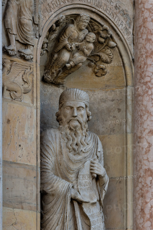 Fidenza, cathedral (Cathedral of San Donnino):
“The Prophet Ezekiel” by Benedetto Antelami.
The prophet holds a scroll that refers to the meaning of the church as the “Gate of Heaven”; it reads: Ezechiel Propheta; vidi portam in domo Domini clausam (Ezekiel Prophet; I saw the door closed in the house of the Lord).
In the dome of the niche is a bas-relief depicting a Madonna and Child surrounded by bunches of flowers and fruit surmounted by an inscription that explains its theological meaning.
Cattedrale di S. Donnino, Fidenza (PR), Emilia Romagna, Italia - Italy
