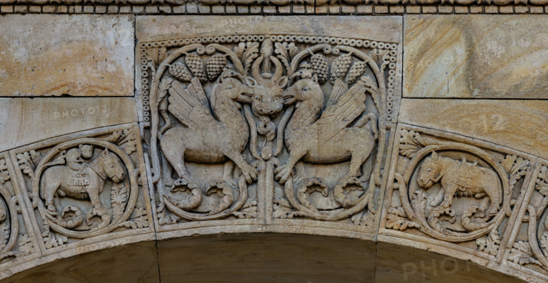 Fidenza, Duomo (Cattedrale di San Donnino), portale destro: dettaglio dell’arco del protiro.
Particolare di due creature fantastiche con una maschera cornuta dal cui ghigno esce un serpente, chiaro riferimento a Satana.
Opera di Benedetto Antelami e bottega.

[ENG]
Fidenza, Duomo (Cathedral of San Donnino), right portal: detail of the arch of the porch.
In the centre, at the top: two fantastic creatures with a horned mask from whose grin a snake emerges, a clear reference to Satan.
Work by Benedetto Antelami e workshop.
Cattedrale di San Donnino, Fidenza (PR), Emilia-Romagna, Italia - Italy