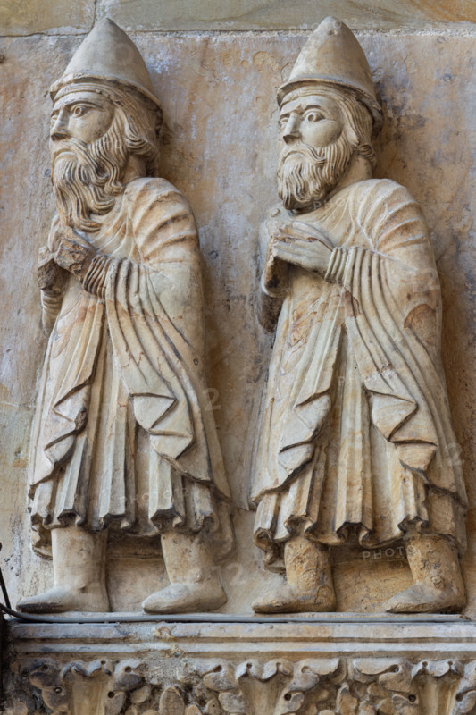 Fidenza, Duomo (Cattedrale di San Donnino), facciata, portale maggiore: dettaglio interno dell’archivolto con due profeti con le mani giunte in cammino verso l’esterno.
Opera di Benedetto Antelami e bottega.

[ENG]
Fidenza, Duomo (Cathedral of San Donnino), facade, main portal: internal detail of the archivolt with two prophets with clasped hands walking outwards.
Work by Benedetto Antelami and workshop.
Cattedrale di San Donnino, Fidenza (PR), Emilia-Romagna, Italia - Italy