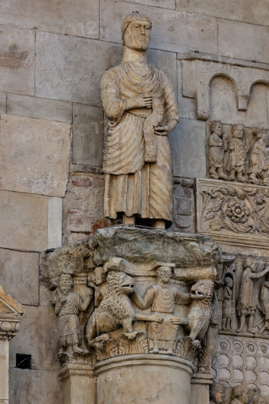 Fidenza, duomo (Cattedrale di San Donnino), sculture tra il portale maggiore e quello di sinistra: 
il capitello con “Daniele nella fossa dei leoni”, sormontato dalla statua con “San Simone Apostolo che mostra la via di Roma ai pellegrini”;
Cattedrale di San Donnino, Fidenza (PR), Emilia-Romagna, Italia - Italy