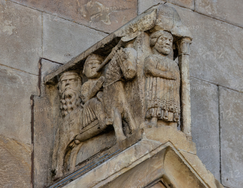 Fidenza, duomo (Cattedrale di San Donnino), portale sinistro, timpano. 
Nell’acroterio sul timpano, é raffigurato un personaggio, probabilmente Oberto II Pallavicino condottiero posto da Federico II di Svevia alla guida della città dal 1249 al 1268. Al suo fianco due suonatori di tromba a cavallo.
Opera di Benedetto Antelami e bottega.

[ENG]
Fidenza, duomo (Cathedral of San Donnino), left portal, tympanum. 
In the acroterion on the tympanum, a character is depicted, probably Oberto II Pallavicino, a leader placed by Frederick II of Swabia at the helm of the city from 1249 to 1268. At his side there are two trumpet players on horseback.
Work by Benedetto Antelami and workshop.
Cattedrale di San Donnino, Fidenza (PR), Emilia-Romagna, Italia - Italy