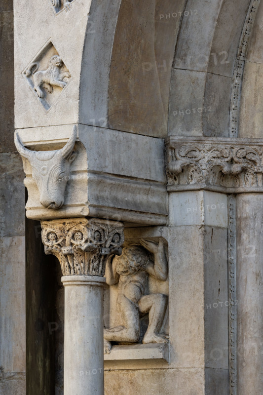 Fidenza, duomo (Cattedrale di San Donnino), facciata, portale sinistro, protiro: telamone, capitello e mensola con bucranio (a sinistra) .
Opera di Benedetto Antelami e bottega.

[ENG]
Fidenza, duomo (Cathedral of San Donnino), façade, left portal, prothyrum: telamon, capital and corbel with bucranium (left).
Work by Benedetto Antelami and workshop.
Cattedrale di San Donnino, Fidenza (PR), Emilia-Romagna, Italia - Italy