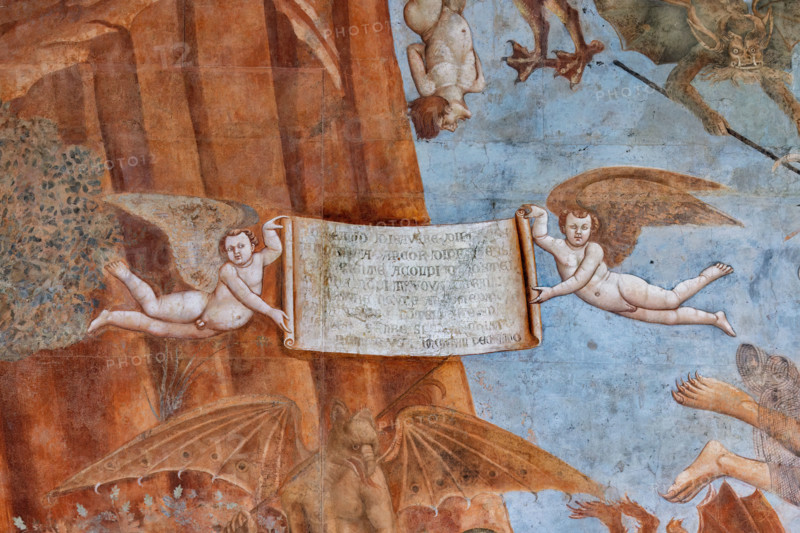 Pisa, Camposanto monumentale: ”Trionfo della Morte”, particolare degli affreschi di Buonamico Buffalmacco, 1336/1341. Dettaglio  con il cartiglio retto da due Geni alati che riporta la lezione che deve trarsi dalla visione dell’insieme: «Schermo di sapere e di ricchezza / di nobiltade e ancora di prodezza / val neente a’ colpi di costei. / Et ancor non si trova contro lei / o lettere veruno argomento. / E non avere l’intelletto spento / di stare sempre sì apparecchiato, / che non ti giunga in peccato mortale».


[ENG]
Pisa, Monumental Cemetery: "Triumph of Death," detail of the frescoes by Buonamico Buffalmacco, 1336/1341.Detail with the cartouche held by two winged Genies which reports the lesson to be learned from the overall view: «A shield of knowledge and wealth / of nobility and even of prowess / is worth nothing against her blows. / And yet no argument can be found against her / or letters. / And do not have your intellect dulled / from always being so prepared, / that you d...