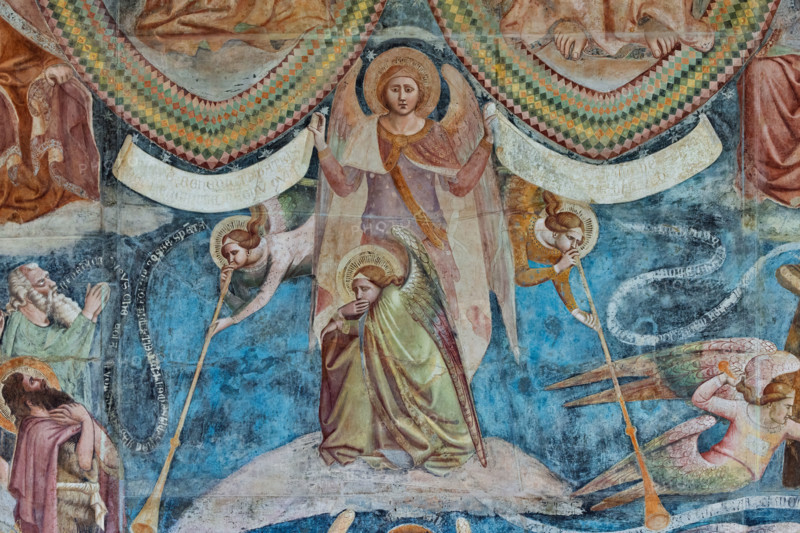 Pisa, Monumental Cemetery: "The Last Judgement”. Frescoes by Buonamico Buffalmacco, 1336/1341.
Detail with a group of angels: two angels playing the tuba, a third crouching and covering his mouth with one hand, and a fourth standing, holding two cartouches; the one on the right reads: "Venite benedicti patris mei, percipite regnum quod vobis paratum est"; the one on the left reads: "ite maledicti in ignem aeternum qui paratus est a diabulo".
Camposanto Monumentale, Pisa (PI), Toscana - Tuscany, Italia - Italy