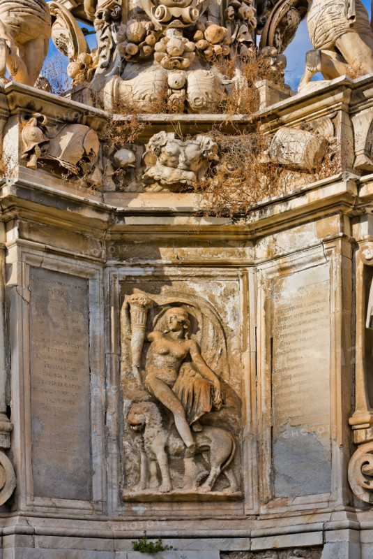 Palermo, Piazza del Parlamento:  il "Teatro Marmoreo",  monumento a Filippo V, prospiciente Palazzo Reale (o "dei Normanni"). Gruppo scultoreo monumentale, è opera dello scultore Gaspare Guercio, di Carlo D'Aprile e Gaspare Serpotta, realizzato per celebrare la gloria di Filippo IV d'Asburgo, re di Spagna e di Sicilia, detto Filippo il Grande. 
Intorno al piedistallo furono disposte le raffigurazioni delle quattro parti della Terra note a quei tempi (Europa, Asia, Africa e America), sulle quali il re di Spagna governava. Sul primo livello furono poste le statue dei quattro Mori, ovvero dei precedenti re dei Paesi andati sotto la sua dominazione. L'opera è adornata da targhe e stemmi dei maggiori casati della Sicilia. L'originaria statua di Filippo IV andò distrutta durante la rivoluzione siciliana del 1848 e fu sostituita nel 1856 dalla statua attuale in marmo che rappresenta il re Filippo V di Spagna e fu eseguita da Nunzio Morello.
Particolare.

[ENG]
Palermo, the Parliament Squ...