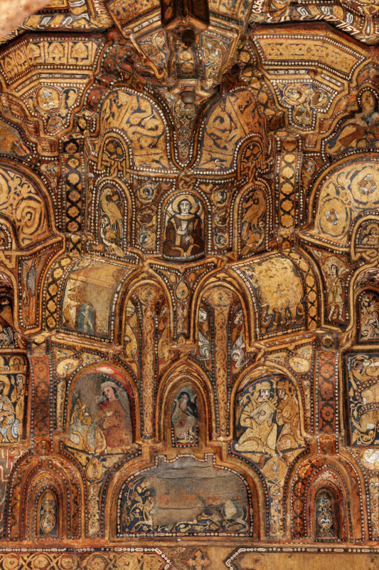 Palermo, Palazzo Reale o Palazzo dei Normanni,  Cappella Palatina (Basilica), navata centrale:  soffitto ligneo, realizzato da maestri di scuola fatimide e costituito da cassoni lignei a muqarnas, dipinte con immagini rare (ornamenti fitoformi e zoomorfi, uccelli, animali fantastici e mitologici, tra cui figure umane in scene di caccia, di guerra e d'amore, suonatori, danzatori e danzatrici del ventre, giocatori di scacchi. Figurazioni generalmente vietate dalla tradizione musulmana) e iscrizioni cufiche (1143). 
Particolare.

[ENG]
Palermo, The Royal Palace or Palazzo dei Normanni (Palace of the Normans), The Palatine Chapel (Basilica), central nave: wooden ceiling, created by Fatimid school masters and consisting of wooden coffers called muqarnas, painted with rare images (phytoform and zoomorphic ornaments, birds, fantastic and mythological animals, including human figures in hunting, making war and  love, players, dancers and belly dancers, chess players: These figures are gene...
