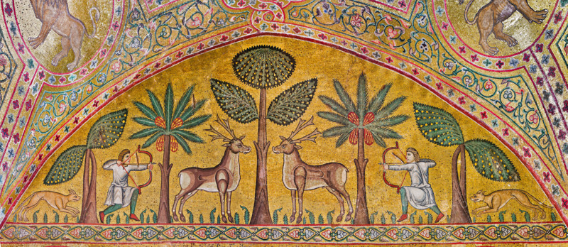 Palermo, Palazzo Reale o Palazzo dei Normanni, Torre Pisana, Sala di Re Ruggero: mosaici della sala voluta da Re Ruggero II d'Altavilla. E' caratterizzata da ampie superfici a mosaico di grande pregio raffiguranti elementi vegetali e scene di carattere aulico e venatorio, simboli del potere normanno (battute di caccia con arcieri e cervi, rappresentati pavoni, cigni, oltre i mitologici centauri, grifi e altri animali esotici  fra lussureggiante vegetazione). I mosaici sono di stile greco - bizantino (secolo XIII).
Particolare con arcieri, cervi, cani  e alberi (banani e palme).

[ENG]
Palermo, The Royal Palace or Palazzo dei Normanni (Palace of the Normans), Pisana Tower,  the King Roger Room: view of the Room which was commissioned by King Roger II d'Altavilla. It is characterized by large mosaic surfaces of great value representing plant elements  and scenes of courtly and hunting style, symbols of the Norman power (hunting scenes with archers and deer, peacocks, swans, and mytho...
