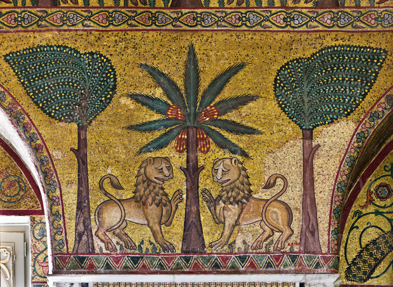 Palermo, Palazzo Reale o Palazzo dei Normanni, Torre Pisana, Sala di Re Ruggero: mosaici della sala voluta da Re Ruggero II d'Altavilla. E' caratterizzata da ampie superfici a mosaico di grande pregio raffiguranti elementi vegetali e scene di carattere aulico e venatorio, simboli del potere normanno (battute di caccia con arcieri e cervi, rappresentati pavoni, cigni, oltre i mitologici centauri, grifi e altri animali esotici  fra lussureggiante vegetazione). I mosaici sono di stile greco - bizantino (secolo XIII).
Particolare con leoni e alberi (banani e palme).

[ENG]
Palermo, The Royal Palace or Palazzo dei Normanni (Palace of the Normans), Pisana Tower,  the King Roger Room: view of the Room which was commissioned by King Roger II d'Altavilla. It is characterized by large mosaic surfaces of great value representing plant elements  and scenes of courtly and hunting style, symbols of the Norman power (hunting scenes with archers and deer, peacocks, swans, and mythological centaurs...