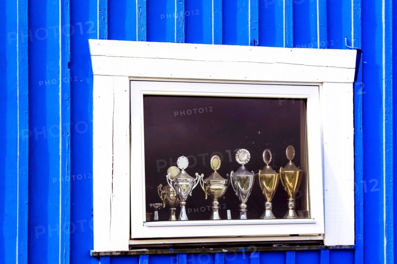 Window display with football cups in a house of the village Ilulissat, Greenland