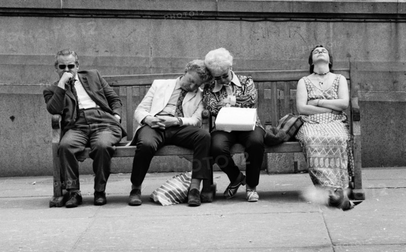 Four People Resting on Street Bench