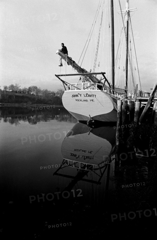 Sailor Adjusting Rigging on Sailboat