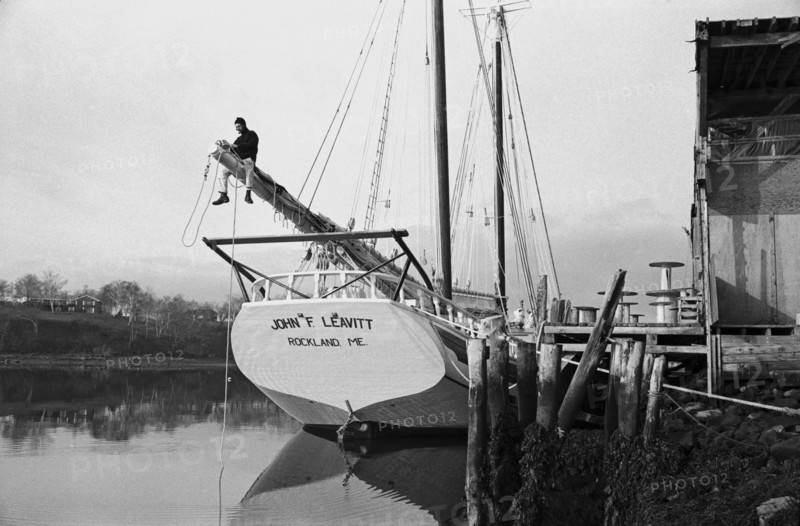 Sailor Adjusting Rigging on Sailboat