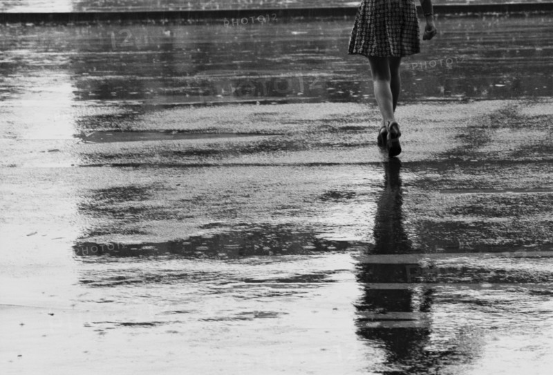 Legs of Woman Crossing Street in Rain