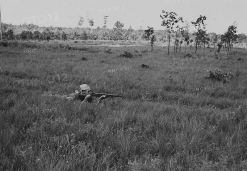 Soldier Laying Down While Displaying Proper Shooting Position in Field During Training Session, WWII, 2nd Battalion, 389th Infantry, US Army Military Base Indiana, USA, 1942