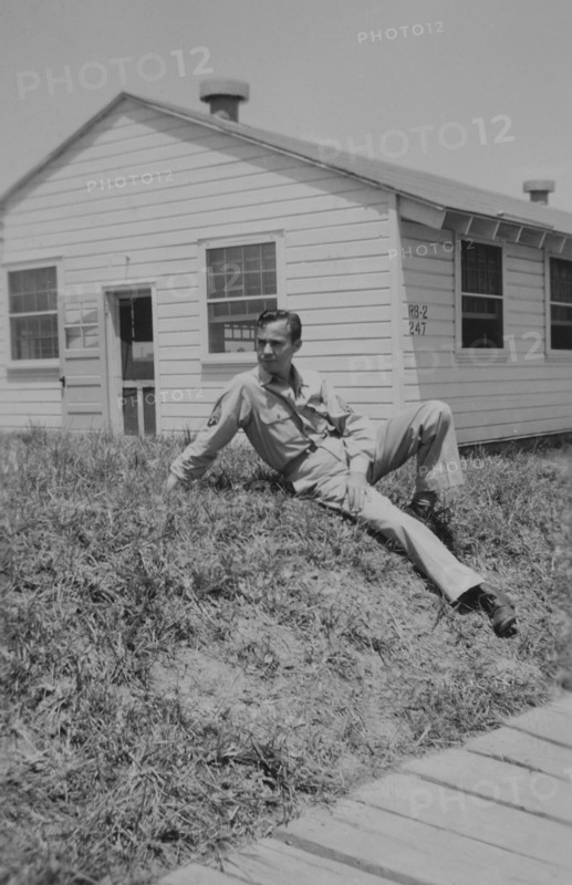 Soldier Relaxing on Ground Near Military Building, WWII, 325th Infantry, US Army Military Base, Camp Claiborne, Louisiana, USA, 1942