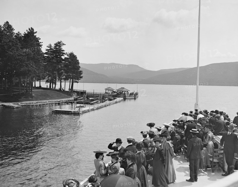 Group of People on Boat Approaching Sagamore Dock, Green Island, Lake George, New York, USA, Detroit Publishing Company, 1904