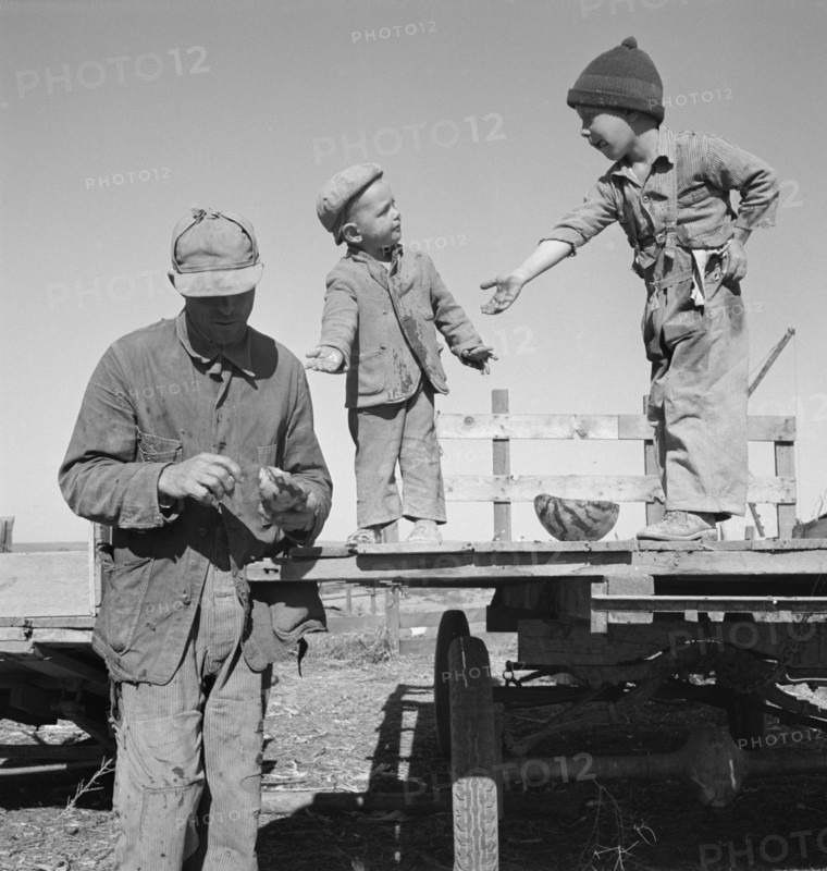 Migrant Worker Giving his Two Sons Watermelon, Dead Ox Flat, Malheur County, Oregon, USA, Dorothea Lange for Farm Security Administration, October 1939