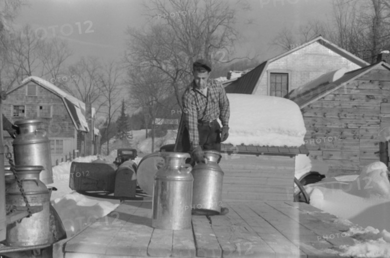 Farmer Bringing Cans of Milk to Crossroads Early in Morning where they are Picked up by Coop Farmers Truck and Delivered to City, near Woodstock, Vermont, USA, Marion Post Wolcott for Farm Security Administration, March 1940