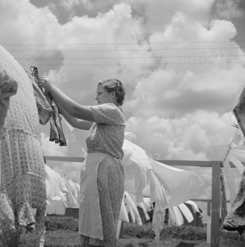 Young Woman Hanging Clothes on Clothesline at Community Laundry Facility, Osceola Migratory Camp, Belle Glade, Florida, USA, Marion Post Wolcott for Farm Security Administration, June 1940