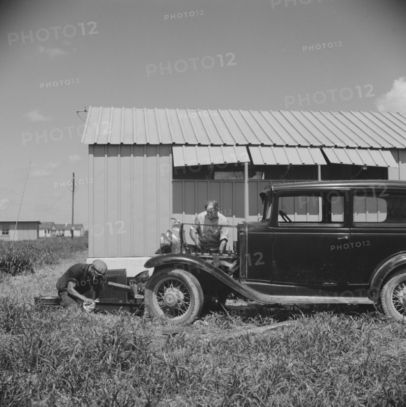Migratory Workers Repairing Car Outside of their Shelter, Osceola Migratory Camp, Belle Glade, Florida, USA, Marion Post Wolcott for Farm Security Administration, June 1940