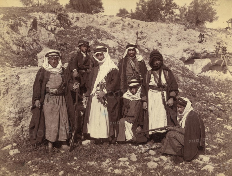 Bedouin Men of Arakat Tribe, Portrait in Rocky Landscape with Swords and Rifles, American Colony Photo Department, early 1900's