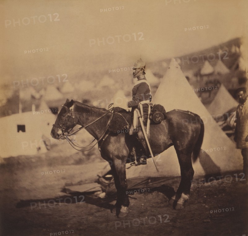 British Major Adolphus Burton, 5th Dragoon Guards, Seated Portrait in Uniform on Horse, Conical Military Tents in Background, Crimean War, Crimea, Ukraine, by Roger Fenton, 1855