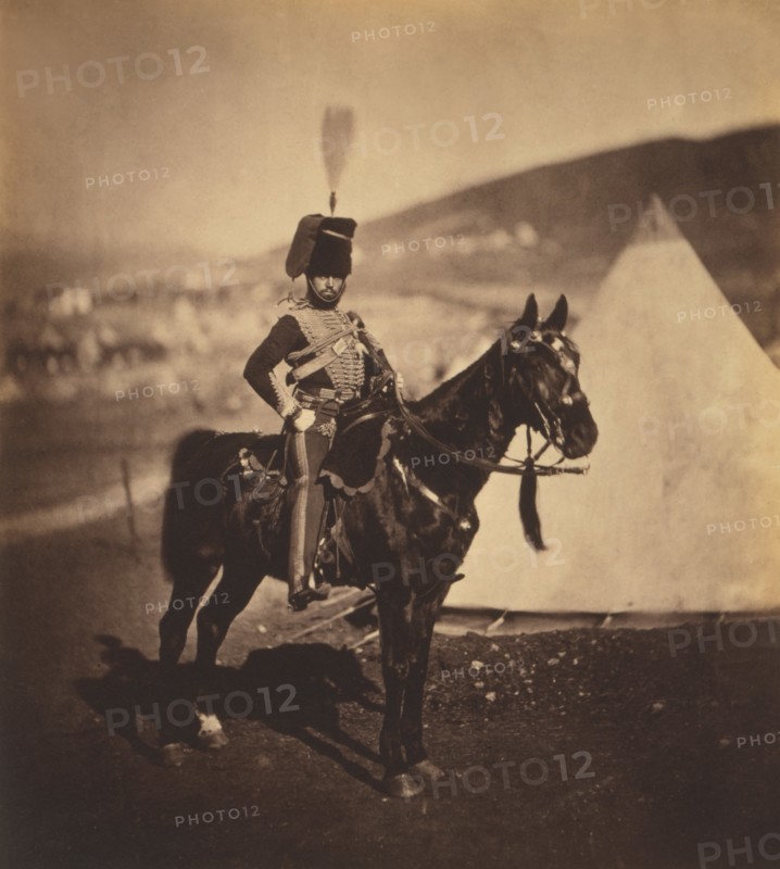 British Cornet Henry John Wilken, 11th Hussars, Seated Portrait in Uniform on Horse, Conical Military Tents in Background, Crimean War, Crimea, Ukraine, by Roger Fenton, 1855