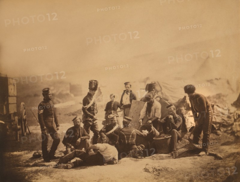 British Soldiers of the 8th Hussars Standing and Sitting around Cooking Pots as Cook Ladles Food into Bowl, Crimean War, Crimea, Ukraine, by Roger Fenton, 1855