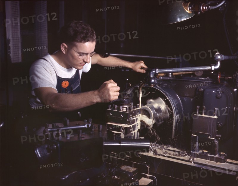 Worker in Machine Shop Finishing Aircraft Part on Huge Turret Lathe, North American Aviation, Inc., Inglewood, California, USA, Alfred T. Palmer for Office of War Information, October 1942