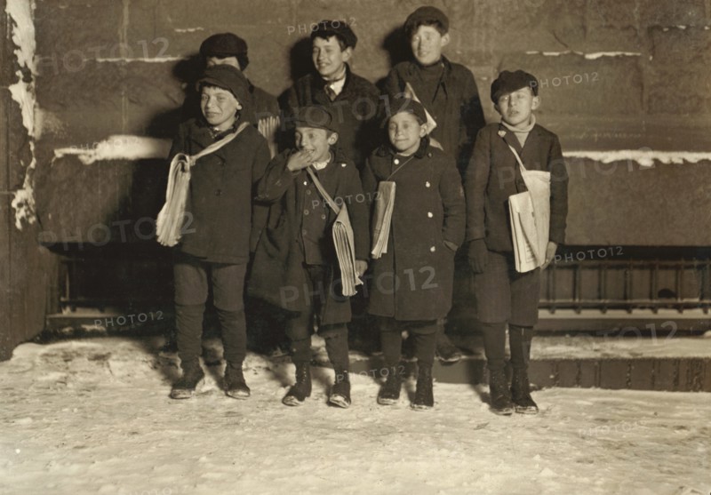 Group of Young Newsies Selling Newspapers at Night, Portrait Standing on Sidewalk in Snow, Hartford, Connecticut, USA, Lewis Hine for National Child Labor Committee, March 1909