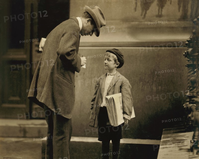 Michael McNelis, 8-year-old Newsboy, just recovering from Pneumonia, found Selling Papers in Rain Storm at time of photo, Portrait with Adult Man, Philadelphia, Pennsylvania, USA, Lewis Hine for National Child Labor Committee, June 1910